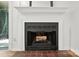 A classic fireplace with white mantle and brick hearth adds charm to the home at 3020 Heathstead Pl # A, Charlotte, NC 28210
