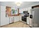 Bright kitchen featuring white cabinets, stainless steel appliances, and stylish wood accent wall at 3020 Heathstead Pl # A, Charlotte, NC 28210