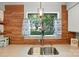 Kitchen area with wood accent wall, stainless sink overlooking backyard at 3020 Heathstead Pl # A, Charlotte, NC 28210