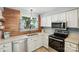 Bright kitchen showcasing stainless appliances, white cabinets, and wood accent wall above countertops at 3020 Heathstead Pl # A, Charlotte, NC 28210