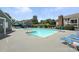 Community swimming pool surrounded by lounge chairs with condo buildings in the background at 3020 Heathstead Pl # A, Charlotte, NC 28210