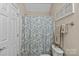 Neutral half bathroom offering a floral shower curtain, coordinated monogrammed towels, and a stylish white toilet at 3020 Waxhaw Crossing Dr, Waxhaw, NC 28173