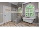 Elegant bathroom showcasing a walk-in shower, a free-standing tub, an arched window, and modern fixtures at 3020 Waxhaw Crossing Dr, Waxhaw, NC 28173