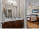 Bright bathroom featuring dark wood cabinets, white countertops, and a view into an adjacent bedroom at 3020 Waxhaw Crossing Dr, Waxhaw, NC 28173