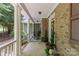 Spacious, covered porch featuring brick accents, elegant decor, and rocking chair at 3020 Waxhaw Crossing Dr, Waxhaw, NC 28173