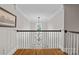 Upstairs landing showcasing hardwood floors, classic banister, and contemporary chandelier at 3020 Waxhaw Crossing Dr, Waxhaw, NC 28173