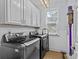 Well-lit laundry room featuring modern washer and dryer units, ample cabinet space, and a window for natural light at 3020 Waxhaw Crossing Dr, Waxhaw, NC 28173