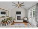 Bright living room boasts a fireplace, ceiling fan, hardwood floors, and abundant natural light from a large window at 3020 Waxhaw Crossing Dr, Waxhaw, NC 28173