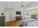 Comfortable main bedroom featuring hardwood floors, a ceiling fan, dresser, and abundant natural light from the windows at 3020 Waxhaw Crossing Dr, Waxhaw, NC 28173