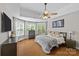 Spacious main bedroom with bay windows, tray ceiling, a ceiling fan, and wood floors at 3020 Waxhaw Crossing Dr, Waxhaw, NC 28173