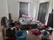 Bedroom with hardwood floors, window, curtains and personal items scattered on the floor at 32891 Nc 49 Hwy, New London, NC 28127
