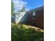 View of home's back exterior and a partial view of shed with a large level yard at 3774 Seaman Dr, Charlotte, NC 28217