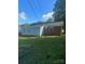 Back exterior of the home featuring a nice flat yard and attached storage at 3774 Seaman Dr, Charlotte, NC 28217