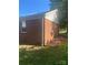 View of home's brick exterior with attached shed and level yard at 3774 Seaman Dr, Charlotte, NC 28217