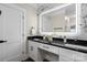 Bright bathroom featuring double sinks, sleek black countertops and white cabinetry at 402 Wildlife Rd, Troutman, NC 28166