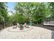 Beautiful backyard firepit surrounded by mature trees offers a relaxing space for entertaining at 402 Wildlife Rd, Troutman, NC 28166