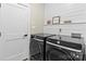 Well-organized laundry room with modern appliances, shiplap accent wall, and farmhouse decor at 402 Wildlife Rd, Troutman, NC 28166