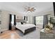 Bright main bedroom featuring a large bed, wood floors, neutral walls, and updated decor at 402 Wildlife Rd, Troutman, NC 28166