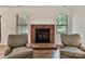Cozy living room featuring a traditional brick fireplace and two comfortable armchairs at 407 Sweetgum Dr # B, Fort Mill, SC 29715