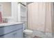 Cozy bathroom with periwinkle vanity, tub/shower combination and decorative shelving at 4116 Tory Path Rd, Waxhaw, NC 28173