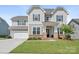 Charming two-story home featuring a manicured lawn, attached garage, and a welcoming front porch at 4116 Tory Path Rd, Waxhaw, NC 28173