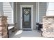 Close up of a home's cozy front porch with stone accents and a decorative wreath on the front door at 4116 Tory Path Rd, Waxhaw, NC 28173