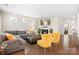 Open living room with hardwood floors, a fireplace, and a comfortable sectional sofa with yellow accents at 4116 Tory Path Rd, Waxhaw, NC 28173