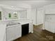 Open-concept kitchen with white cabinetry, stainless appliances, and hardwood floors at 424 Mallard Dr, Pineville, NC 28134