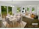 Bright, staged living and dining area featuring neutral tones and large windows for natural light at 424 Mallard Dr, Pineville, NC 28134