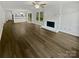 Open-concept living room with wood-look floors, fireplace, and breakfast bar into the kitchen at 424 Mallard Dr, Pineville, NC 28134