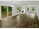 Spacious living room with wood-look flooring, brick fireplace, and sliding doors to the backyard at 424 Mallard Dr, Pineville, NC 28134