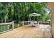 Inviting wood back deck with furniture set amidst a lush, tree-filled backyard at 5221 Javitz Rd, Charlotte, NC 28216
