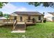 Back exterior view of home with wooden deck and stairs to landscaped backyard at 5221 Javitz Rd, Charlotte, NC 28216