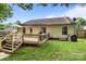Rear exterior view of a home featuring a wooden deck, grill and lush green backyard at 5221 Javitz Rd, Charlotte, NC 28216