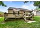 Rear exterior view of a home featuring a wooden deck and lush green backyard at 5221 Javitz Rd, Charlotte, NC 28216