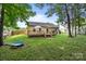 Green backyard with stone pathway leading to rear exterior of home featuring wooden deck at 5221 Javitz Rd, Charlotte, NC 28216
