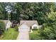 Beautiful single-story house with attached garage, manicured lawn, and lush, mature trees providing curb appeal at 5221 Javitz Rd, Charlotte, NC 28216
