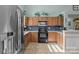 Charming kitchen with stainless steel appliances, wood cabinets and tile floors at 5221 Javitz Rd, Charlotte, NC 28216