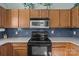 Kitchen with oak cabinets, stainless steel microwave and glass tile backsplash at 5221 Javitz Rd, Charlotte, NC 28216