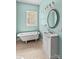 Traditional bathroom featuring claw foot tub, pedestal sink, decorative mirror and natural light at 524 W Horah St, Salisbury, NC 28144
