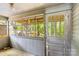Enclosed porch featuring wood paneling, a grid of windows, and a screened door at 524 W Horah St, Salisbury, NC 28144