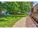 Large backyard featuring a gravel path, lush grass, and a seating area at 5610 Monticello Nw Dr, Concord, NC 28027