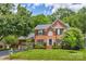 Traditional brick home with manicured lawn, mature trees, and a two-car garage at 5610 Monticello Nw Dr, Concord, NC 28027