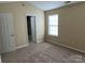 Neutral bedroom with carpeted floors, a window, and a vaulted ceiling provides a comfortable space at 6130 Sid Crane Dr, Charlotte, NC 28216