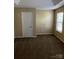 A bedroom with a neutral color scheme, featuring a window and a door for easy access at 6130 Sid Crane Dr, Charlotte, NC 28216