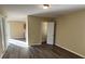 Open living area with dark wood floors, light walls, and kitchen access at 6130 Sid Crane Dr, Charlotte, NC 28216