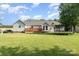 Expansive backyard with a wooden deck, lush green lawn, and mature trees for shade at 614 W Peeler St, Salisbury, NC 28146