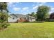 Large backyard with a green lawn, mature trees, a trampoline and a wooden deck at 614 W Peeler St, Salisbury, NC 28146