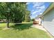 Large grassy backyard featuring a trampoline, deck and beautiful mature trees at 614 W Peeler St, Salisbury, NC 28146