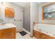 Bathroom has wood cabinets, combination shower and tub, and large window at 614 W Peeler St, Salisbury, NC 28146